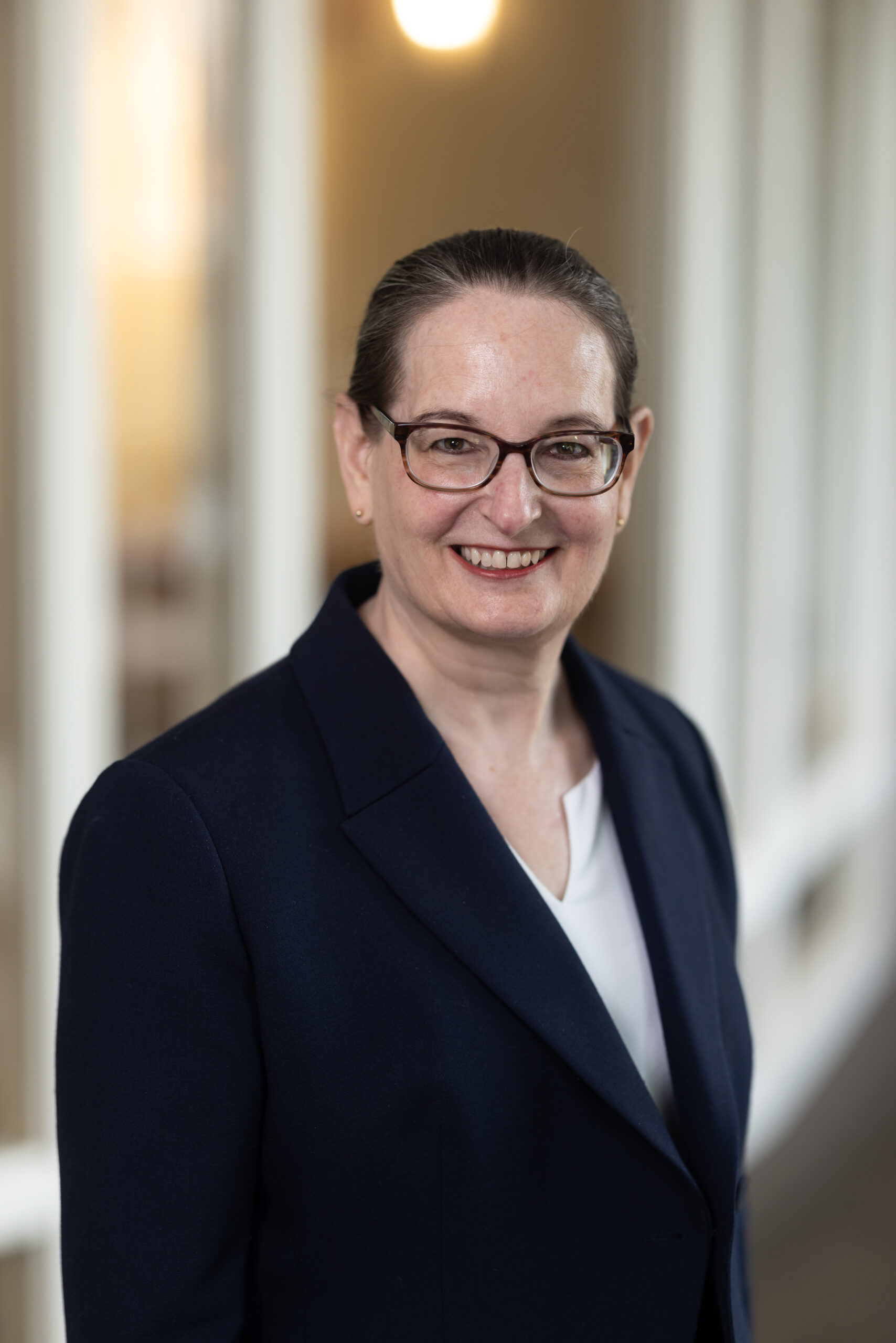 Portrait of Beth M. Sheppard with glasses and blue suit jacket.
